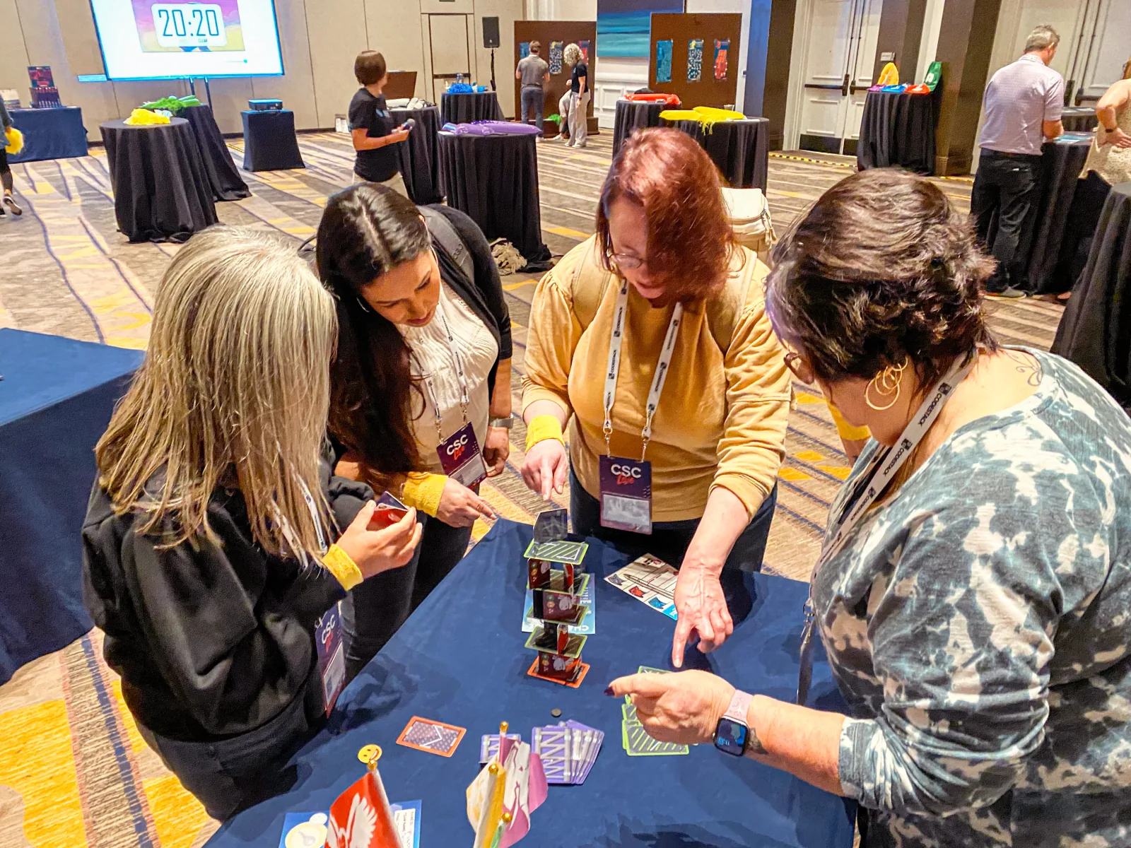 Leadership team works through a card tower challenge under a countdown clock